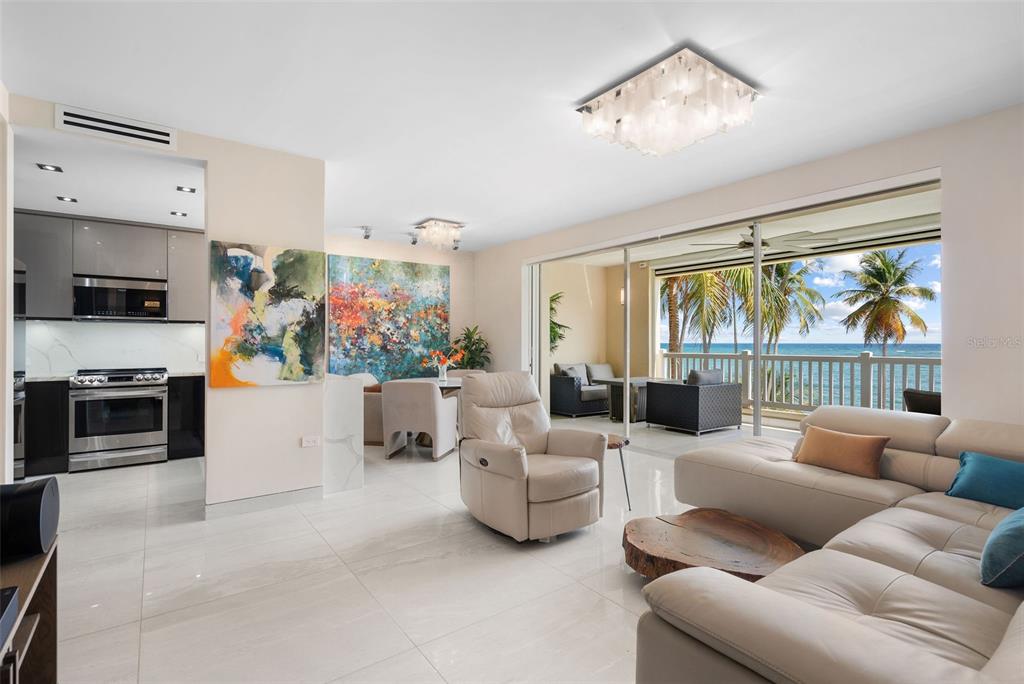A modern living room and kitchen area open to a balcony with ocean views — 400 OCEAN DRIVE UNIT 423, HUMACAO, PR