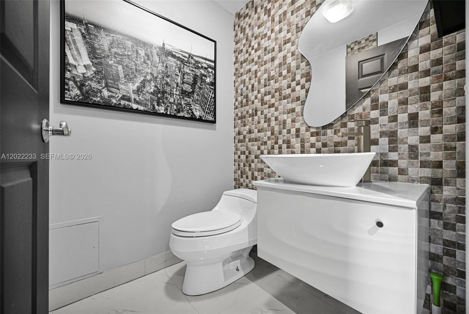 A modern bathroom features a vessel sink, a mosaic tile wall, and a city-themed print — 6001 N Ocean Dr # 1203, Hollywood FL 33019, HOLLYWOOD, FL