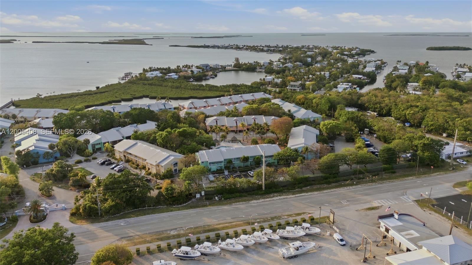An aerial view shows a multi-building residential complex situated near a coastal waterway — 98282 Windward Ave # 2, Key Largo FL 33037, KEY LARGO, FL