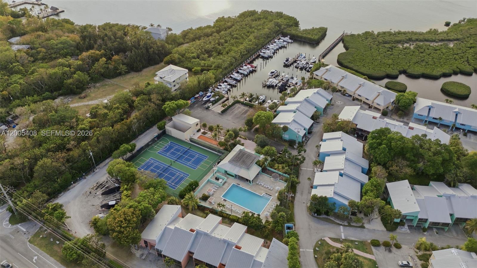 An aerial view shows a residential complex with a marina, tennis courts, and a pool — 98282 Windward Ave # 2, Key Largo FL 33037, KEY LARGO, FL