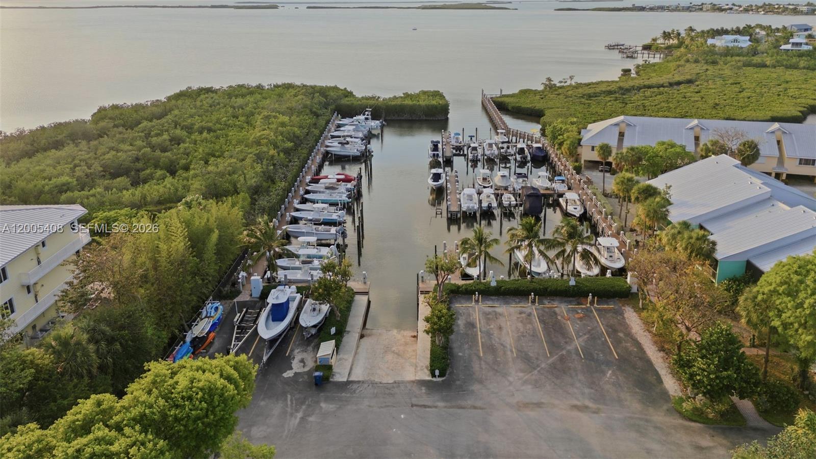 An aerial view shows a boat marina with multiple slips, docked vessels, and a parking lot — 98282 Windward Ave # 2, Key Largo FL 33037, KEY LARGO, FL