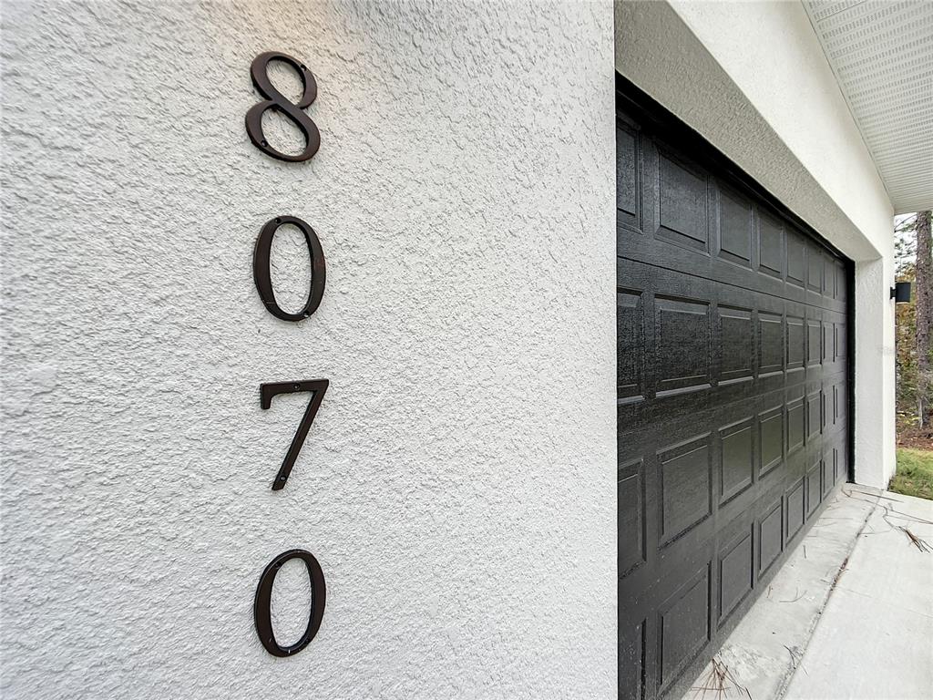 The house number 8070 is mounted vertically on a white stucco exterior wall — 8070 SW 131ST LANE, OCALA, FL