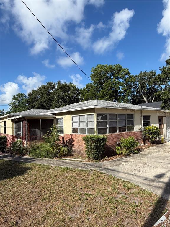 A single-story house with a brick base, light-colored siding, and a screened-in porch — 1010 PENNSYLVANIA AVENUE, CLEARWATER, FL