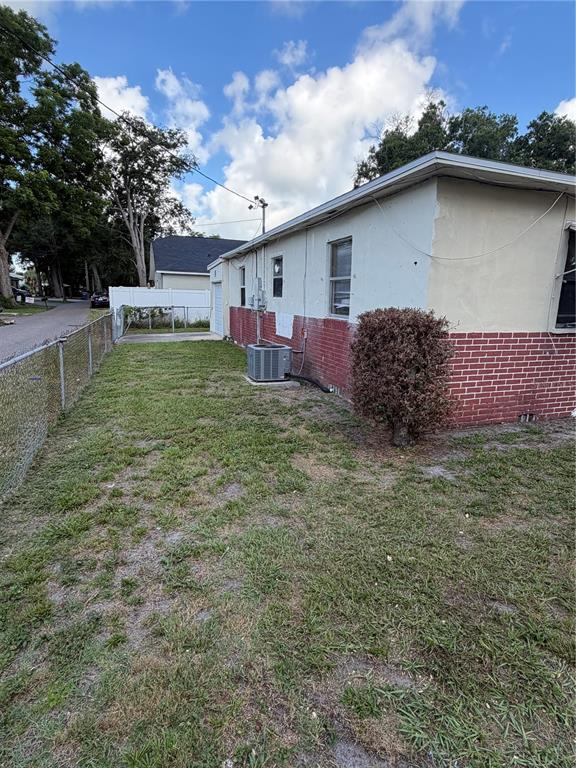 The exterior of a single-story house features a brick and stucco facade with an AC unit — 1010 PENNSYLVANIA AVENUE, CLEARWATER, FL