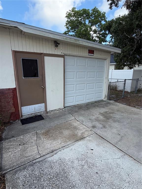 An exterior view of a garage featuring a brown door and a white sectional door — 1010 PENNSYLVANIA AVENUE, CLEARWATER, FL