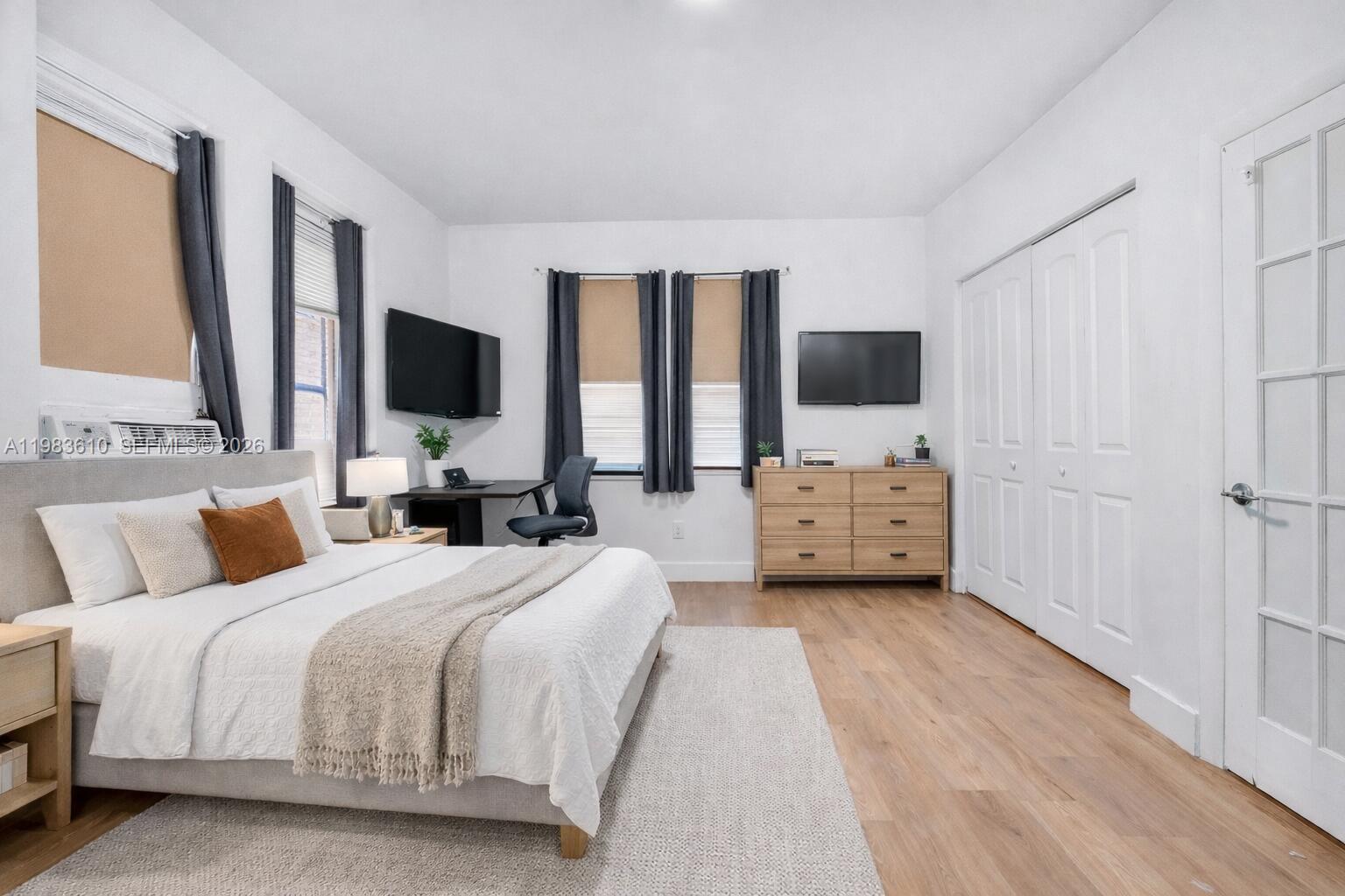 A bedroom features a bed, a desk, a dresser, two televisions, and light wood flooring — 1554 SW 5th St # 11c, Miami FL 33135, MIAMI, FL
