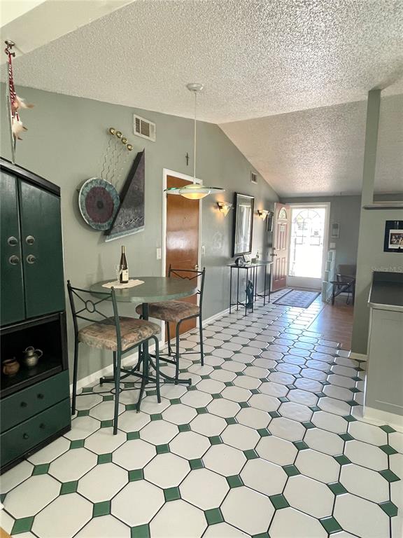 A dining area features a round table, two chairs, and white tile flooring with green accents — 6944 LARCHMONT AVE, NEW PORT RICHEY, FL