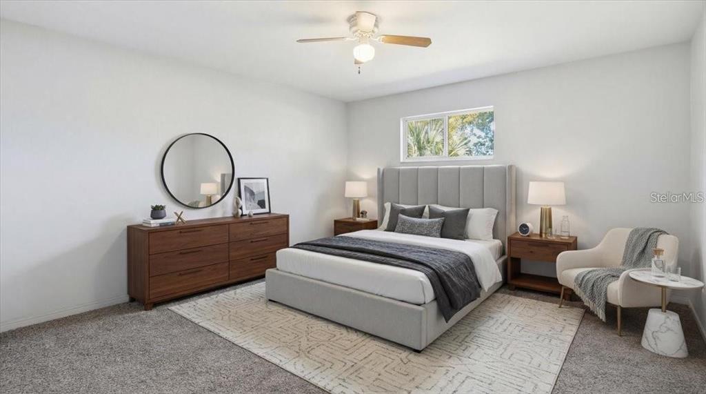 A bedroom features a gray upholstered bed, wooden dresser, and a cream-colored accent chair — 5991 FAIRFIELD AVENUE S, GULFPORT, FL