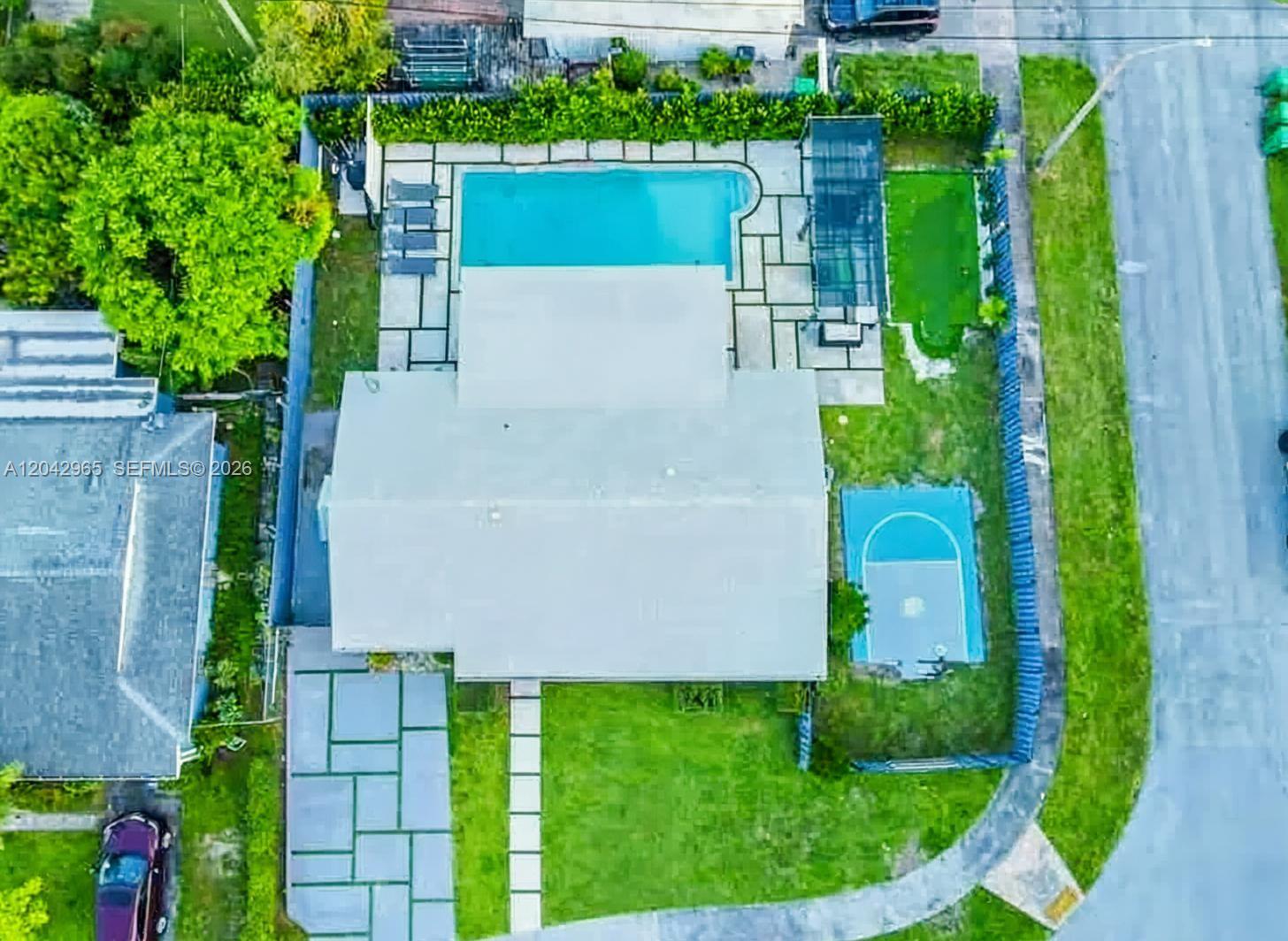 An aerial view shows a house with a swimming pool, basketball court, and paved yard — 10010 SW 162nd St, Miami FL 33157, MIAMI, FL