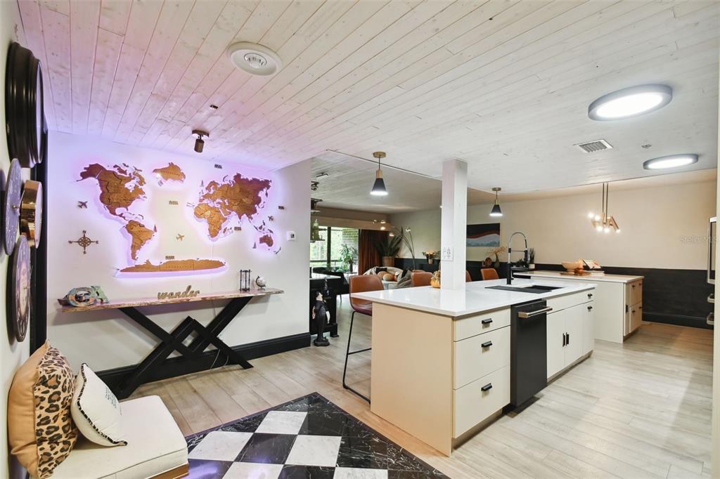 A kitchen with a white island, wood-plank ceiling, and a backlit world map wall feature — 36750 US HIGHWAY 19 N UNIT 20305, PALM HARBOR, FL