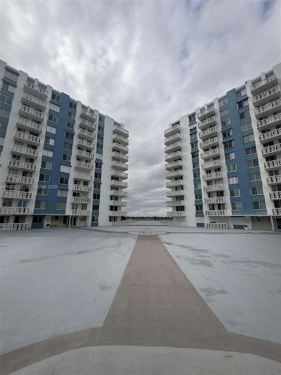 A wide-angle exterior view shows two identical blue and white residential towers facing each other — 925 N Halifax # 102, Daytona FL 32118, DAYTONA, FL