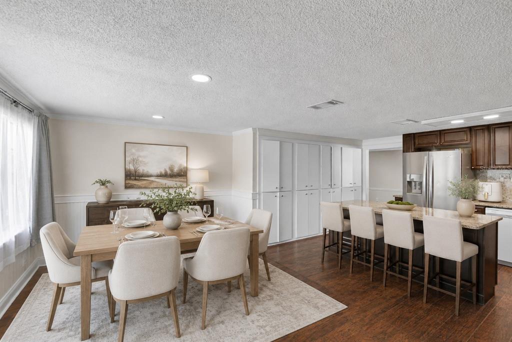A kitchen features dark wood cabinets, a granite-topped island, and an adjacent dining area — 918 JERE CIRCLE, LAKELAND, FL