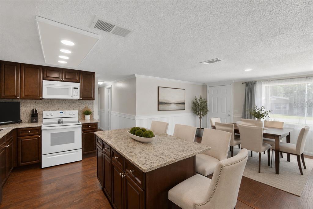 A living room features a large sectional sofa, a fireplace, and a television on shelving — 918 JERE CIRCLE, LAKELAND, FL