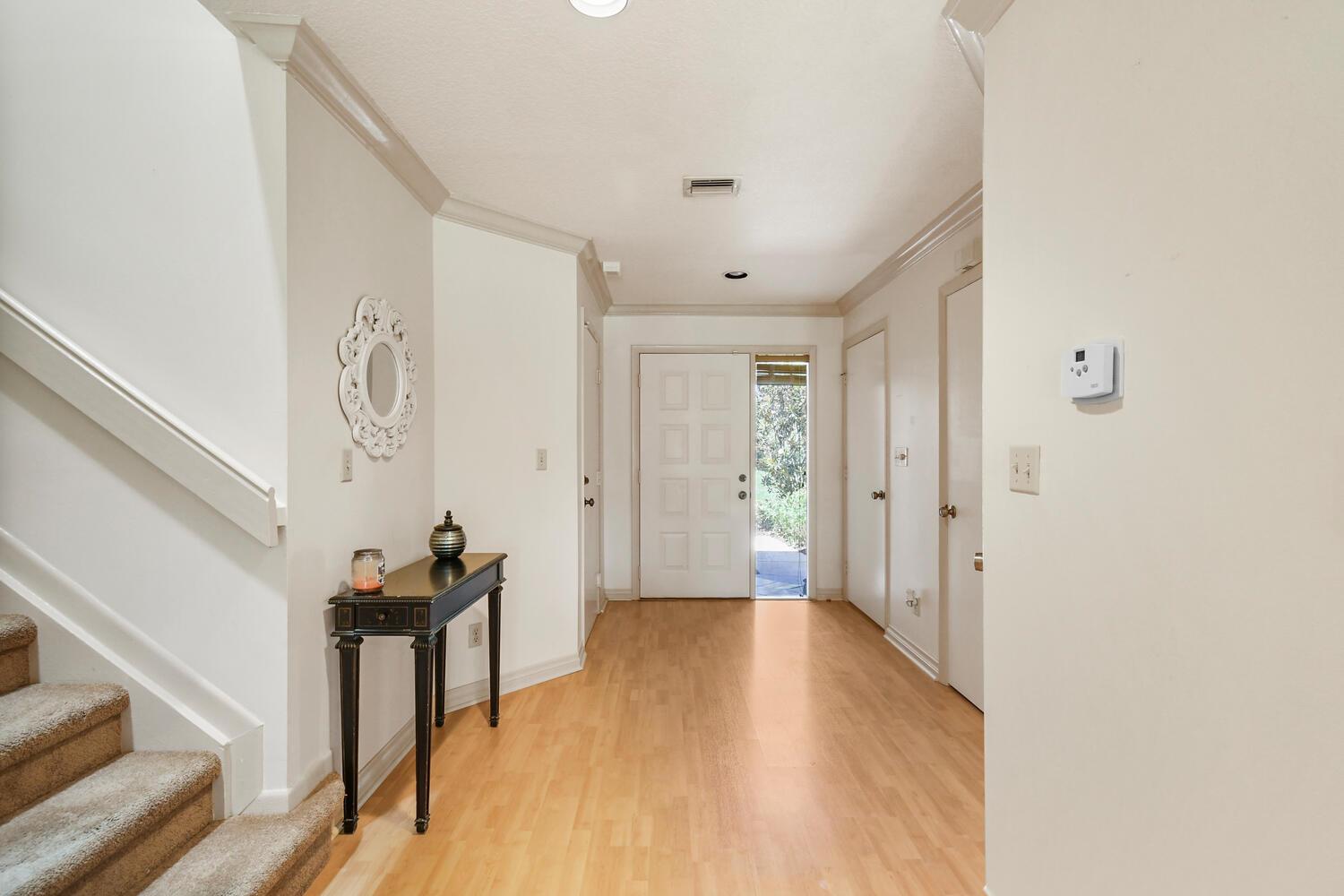 A bright entryway features light wood flooring, a staircase with carpeted steps, and a front door — 5266 Sapphire Valley, Boca Raton FL 33486, BOCA RATON, FL