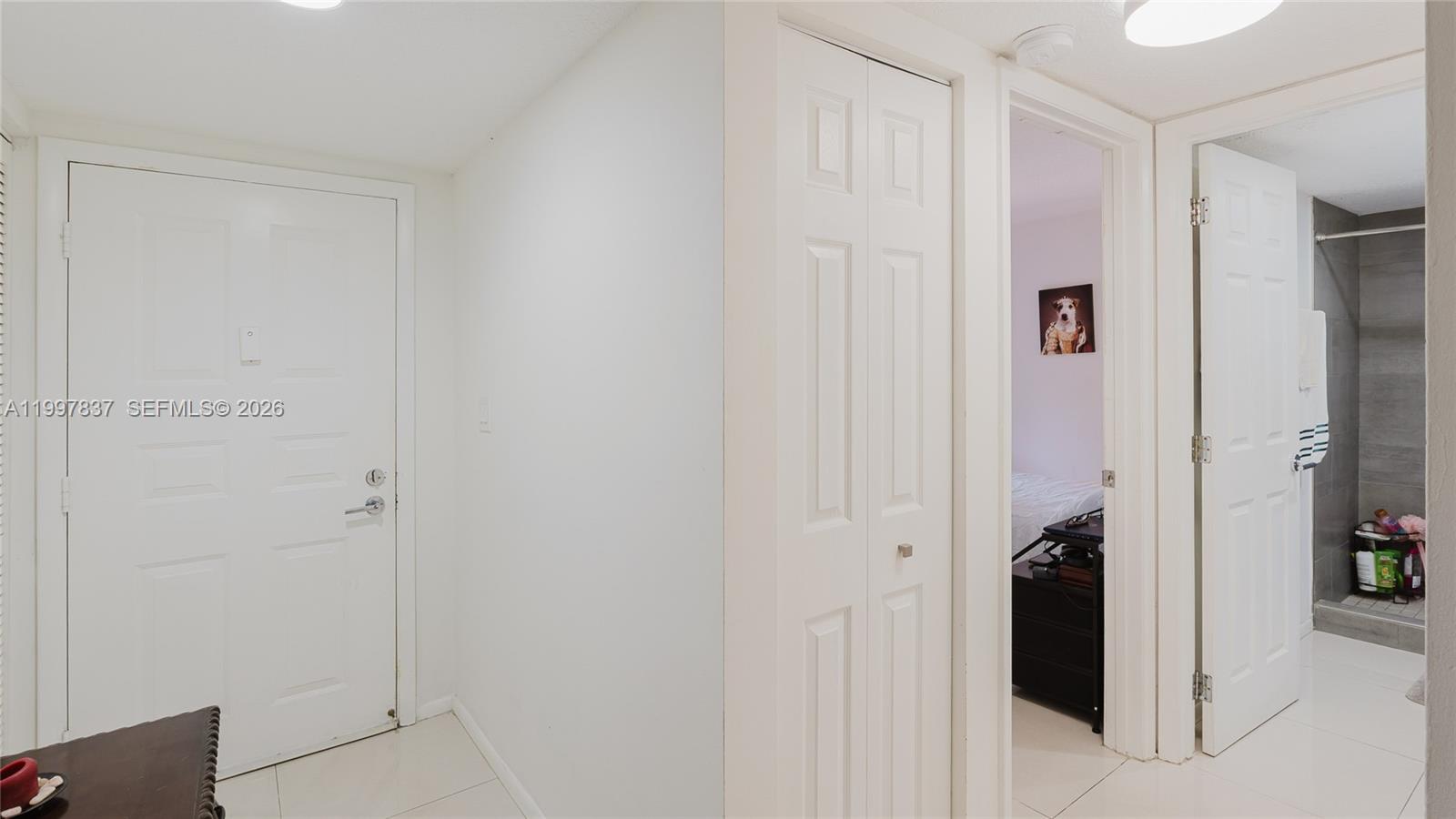 A white interior hallway features a front door, a closet, and two open doorways — 101 SW 96th Ter # 101, Plantation FL 33324, PLANTATION, FL