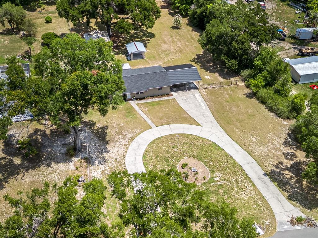 An aerial view shows a house with a metal roof, carport, and circular concrete driveway — 4722 STEARNS ROAD, VALRICO, FL