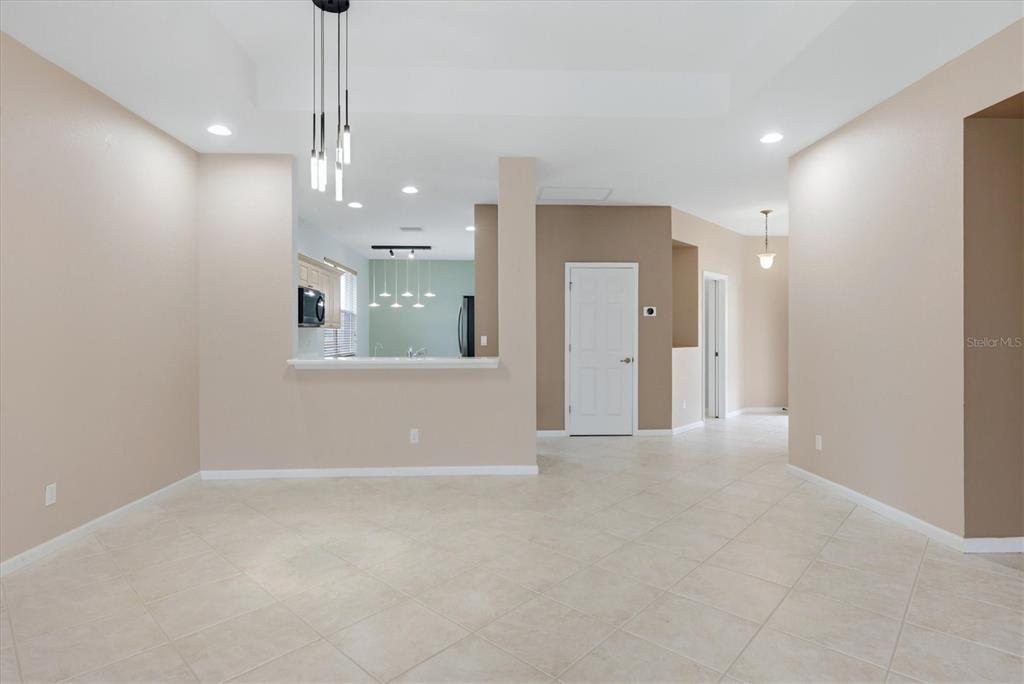 A dining area with tile floors, a breakfast bar, and a modern pendant light fixture — 3275 OSPREY LANE, PORT CHARLOTTE, FL