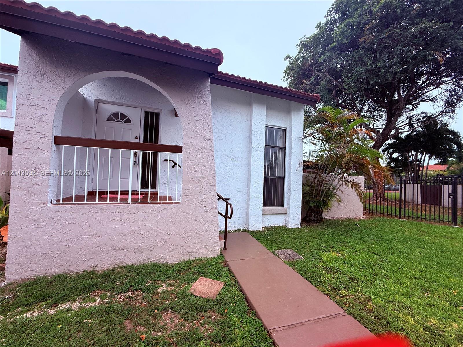 A pink and white stucco house features a covered entryway with a white railing — 9909 NW 9th St Cir # 3, Miami FL 33172, MIAMI, FL