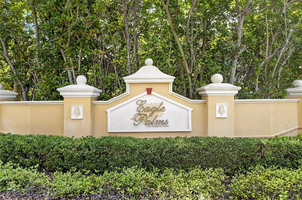 A tan stucco monument sign for Eagle Palms at The Preserve North sits behind hedges — 8833 MOONLIT MEADOWS LOOP, RIVERVIEW, FL