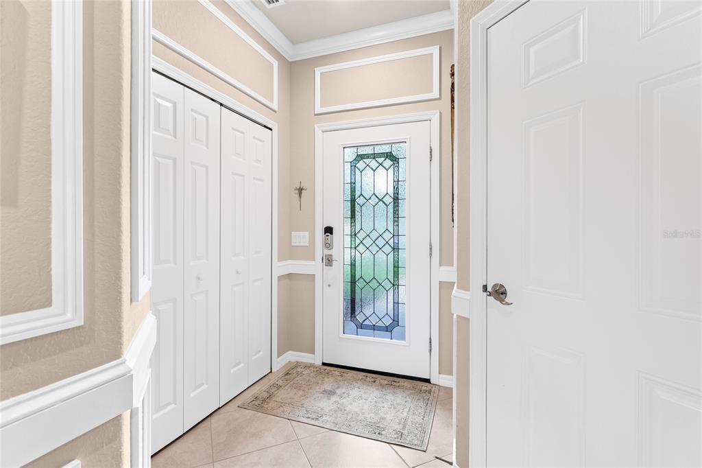An entryway features a white front door with a decorative glass insert and tiled flooring — 20185 LAGENTE CIRCLE, VENICE, FL