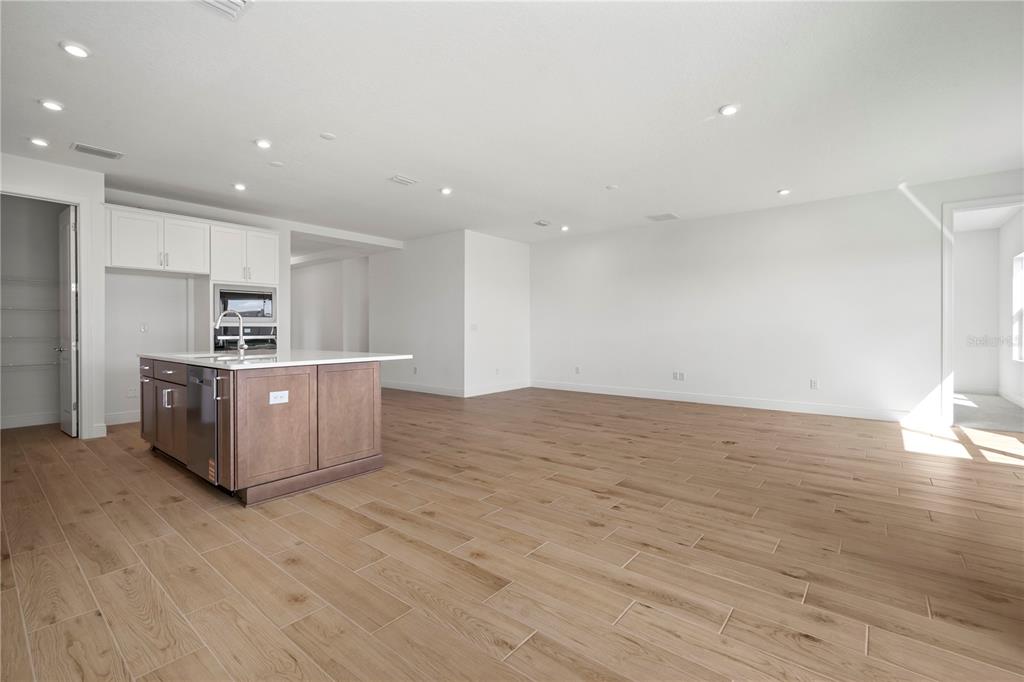 An open-concept kitchen with a wooden island and light wood-look tile flooring — 2945 STEWART CREEK CIRCLE, PLANT CITY, FL