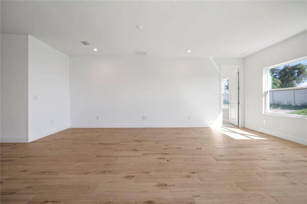 An empty room with white walls, recessed lighting, and light wood-look tile flooring — 2945 STEWART CREEK CIRCLE, PLANT CITY, FL