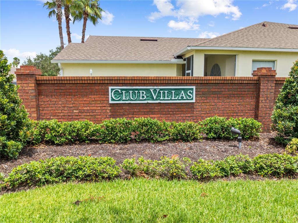 A brick wall with a Club Villas sign stands in front of a house — 153 CLUB VILLAS LANE, KISSIMMEE, FL
