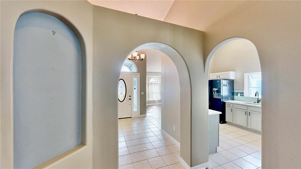 An arched entryway leads to a tiled hallway with a view of the front door — 3016 CRYSTAL CREEK BOULEVARD, ORLANDO, FL