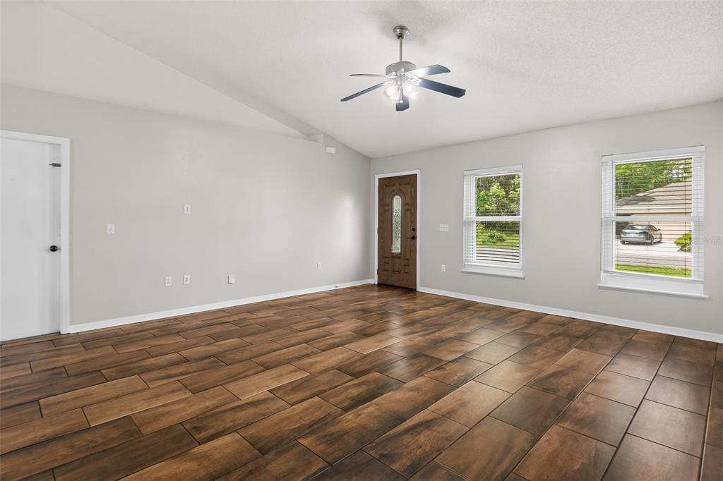 A living room with light gray walls, wood-look tile flooring, and a ceiling fan — 51 BEAVERDAM LANE, PALM COAST, FL