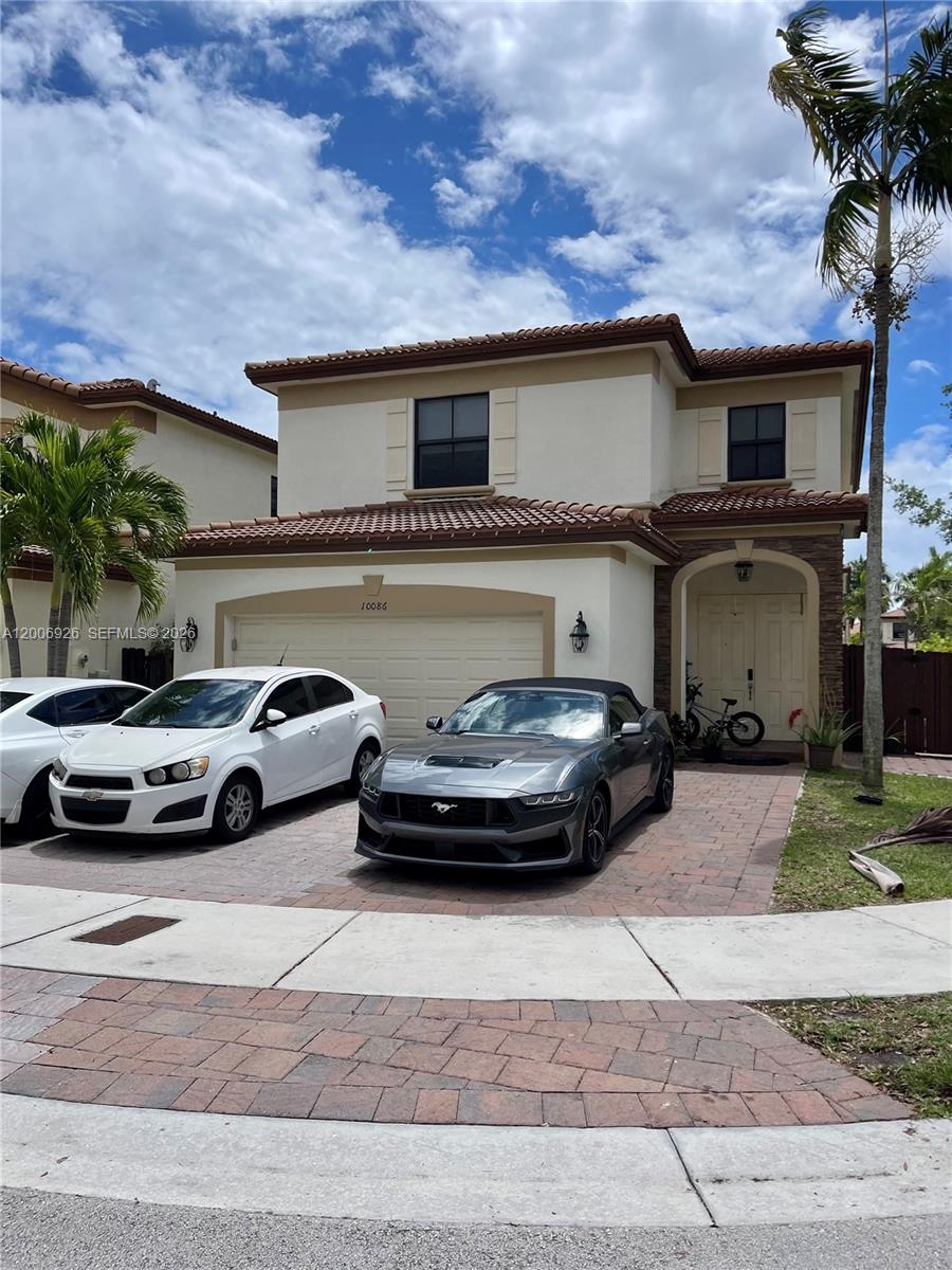 A two-story house with a tiled roof, a two-car garage, and two cars parked outside — 10086 NW 89th Ter, Doral FL 33178, DORAL, FL