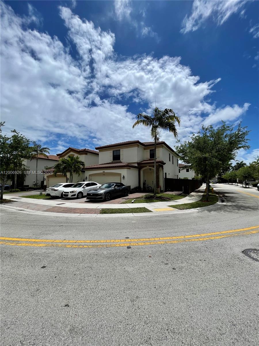 A two-story residential house with a driveway and palm trees under a cloudy sky — 10086 NW 89th Ter, Doral FL 33178, DORAL, FL