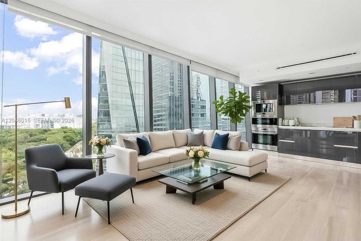 A modern living room features a sectional sofa, glass coffee table, and floor-to-ceiling windows — 1451 Brickell Ave # 1404, Miami FL 33131, MIAMI, FL