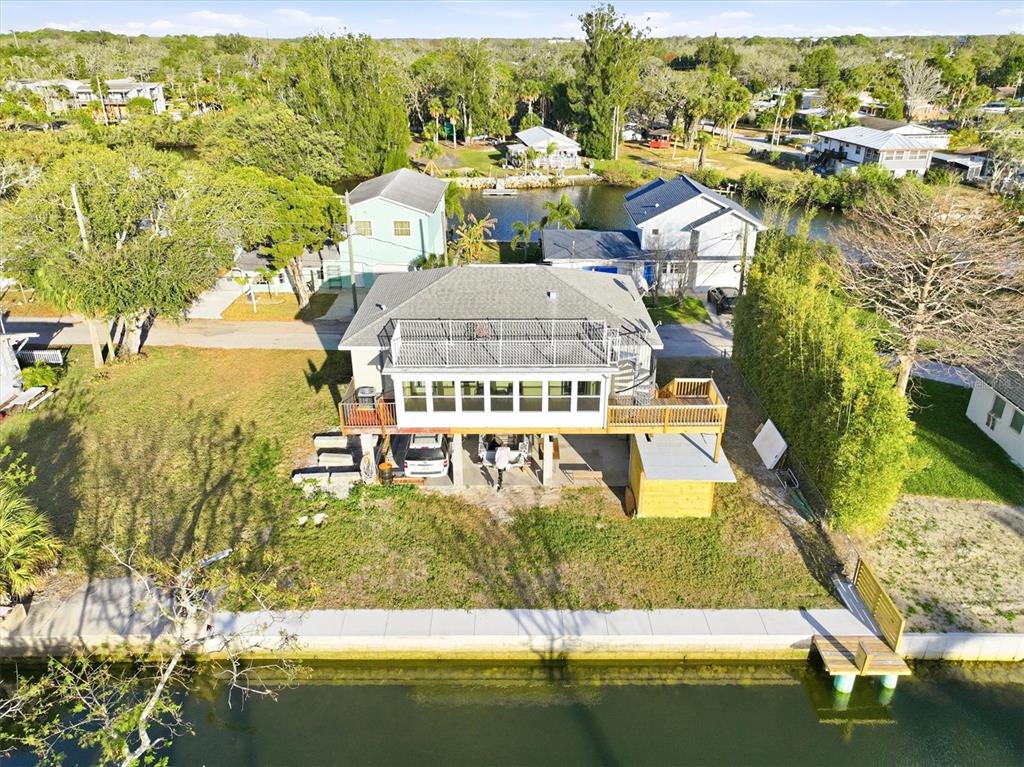 An aerial view of a waterfront house with a raised deck and a private dock — 14203 SHILOH COURT, HUDSON, FL