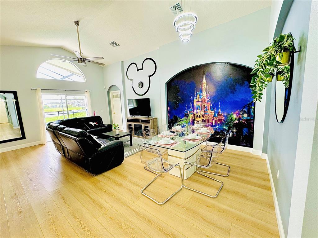 A living and dining area features light wood floors, a castle mural, and Mickey Mouse decor — 4647 CUMBRIAN LAKES DRIVE, KISSIMMEE, FL