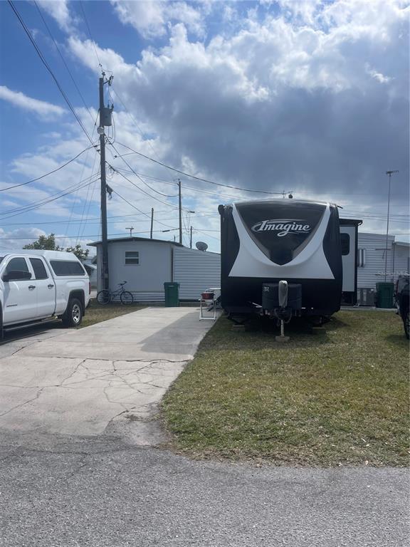 A travel trailer is parked on a concrete pad next to a white mobile home — 40 ILLINOIS STREET, PALMETTO, FL
