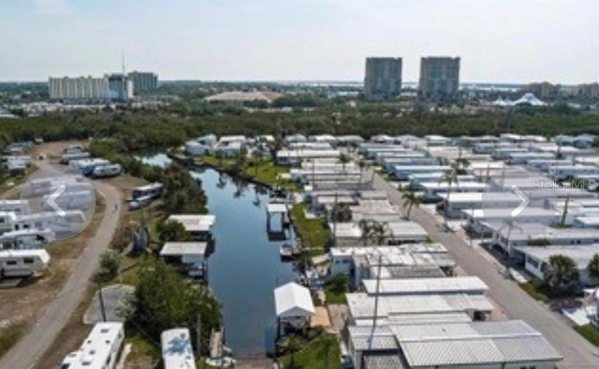 An aerial view shows a mobile home park with a central canal and nearby buildings — 40 ILLINOIS STREET, PALMETTO, FL