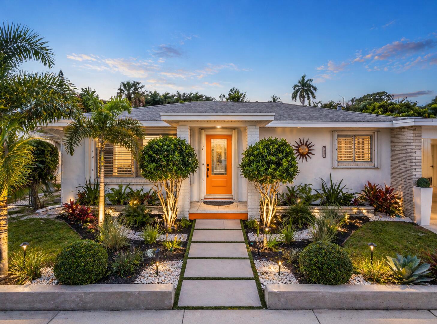 A single-story house with an orange front door, a paved walkway, and illuminated landscaping — 1428 N M Street, Lake Worth FL 33460, LAKE WORTH, FL