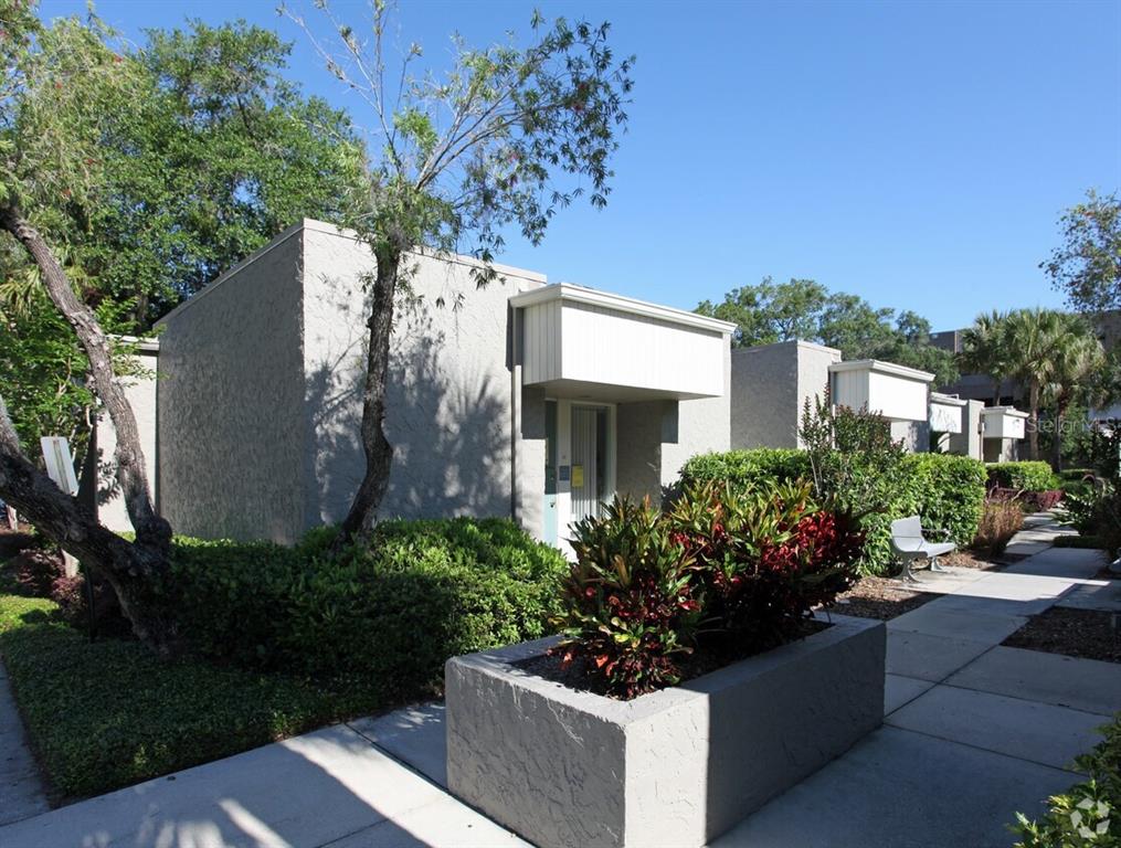 A concrete walkway leads past a low planter to the entrance of a stucco building — 331 N MAITLAND AVE, MAITLAND, FL