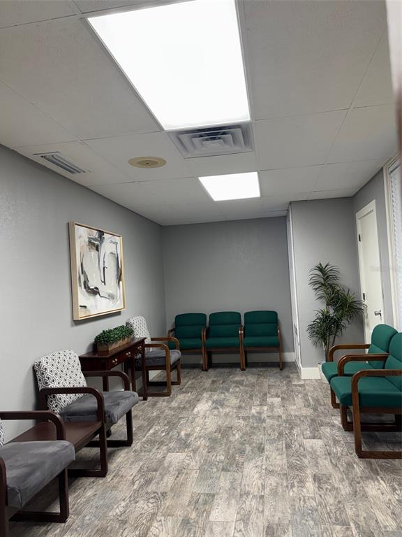 A waiting room features gray walls, wood-look tile flooring, and several green and patterned chairs — 331 N MAITLAND AVE, MAITLAND, FL