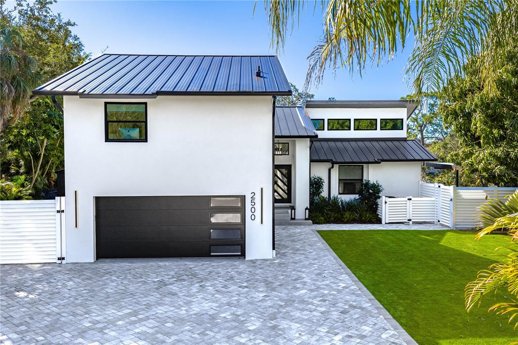 A modern white house with a black metal roof and a paved driveway — 2500 MONTEREY STREET, SARASOTA, FL
