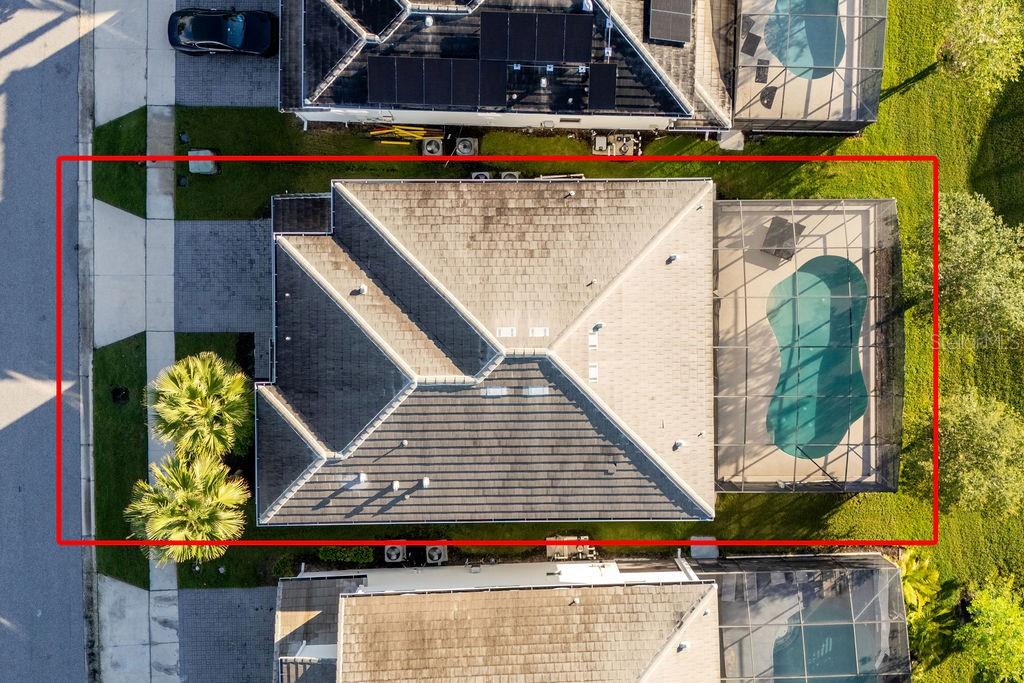 An aerial view shows a house with a shingled roof and a screened-in swimming pool — 2692 CALISTOGA AVENUE, KISSIMMEE, FL
