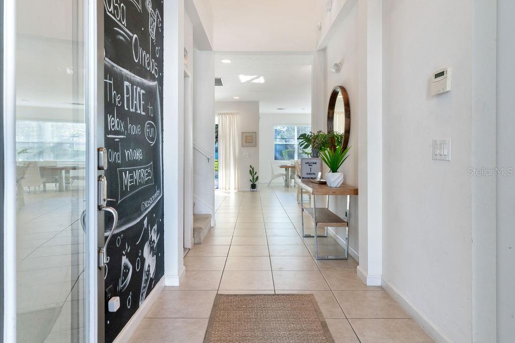A tiled entryway leads into a bright, open-concept living space with a chalkboard wall — 2692 CALISTOGA AVENUE, KISSIMMEE, FL