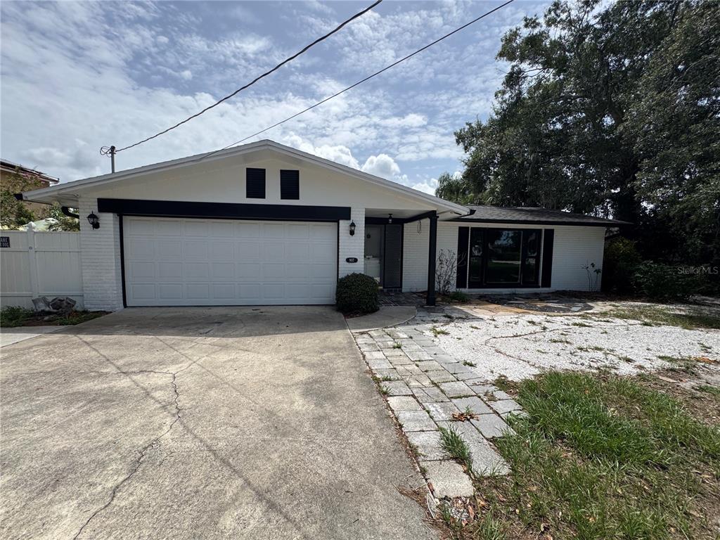 A single-story white brick house features a two-car garage and a stone walkway — 907 S FLORIDA AVENUE, TARPON SPRINGS, FL