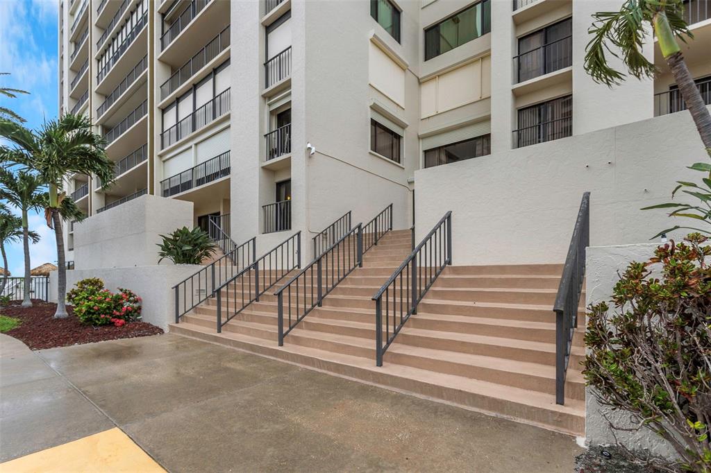 A set of concrete stairs with metal railings leads to the entrance of a building — 1480 GULF BOULEVARD UNIT 506, CLEARWATER BEACH, FL