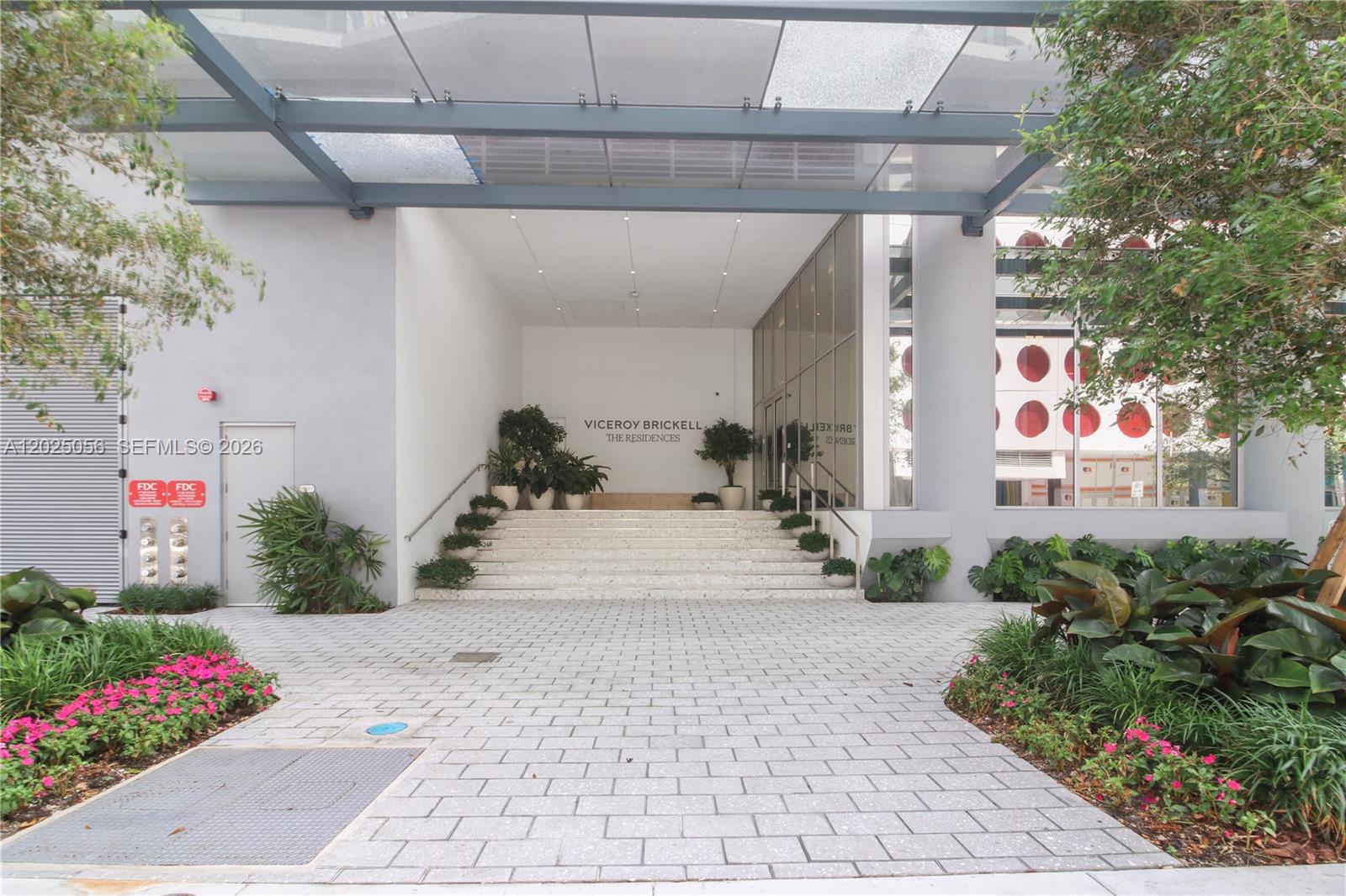 The entrance to a building features a stone staircase leading to a glass-walled lobby — 77 SE 5th St # 4208, Miami FL 33131, MIAMI, FL