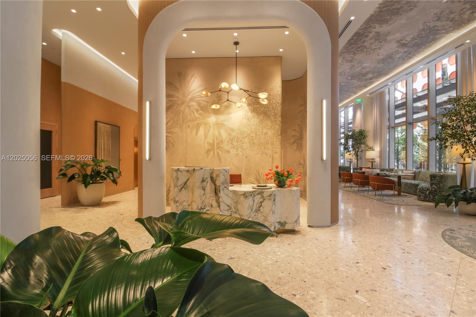 A modern lobby features a marble reception desk, arched architectural details, and large potted plants — 77 SE 5th St # 4208, Miami FL 33131, MIAMI, FL