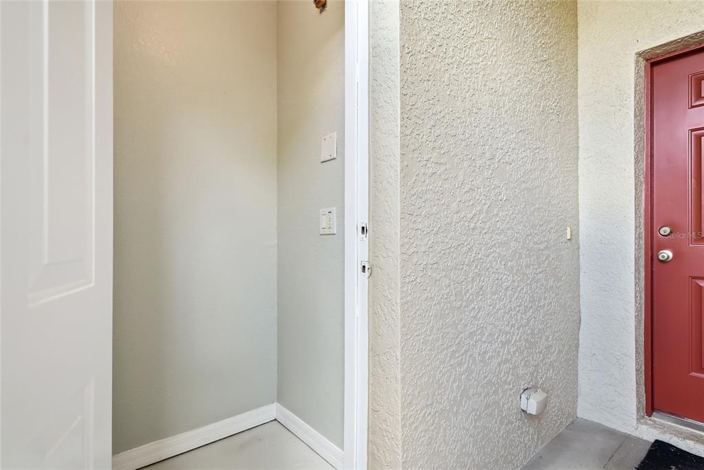 A small exterior storage closet with a white door next to a red entry door — 11023 WINTER CREST DRIVE, RIVERVIEW, FL