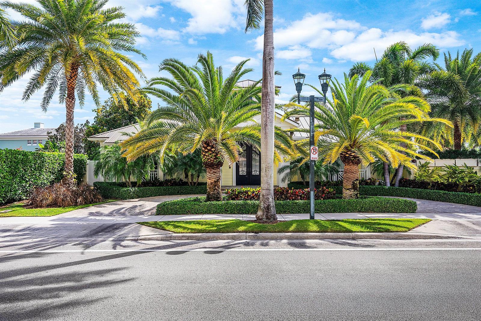 A yellow house with a palm-lined driveway and a street lamp in the foreground — 201 NE 3rd Court, Boca Raton FL 33432, BOCA RATON, FL