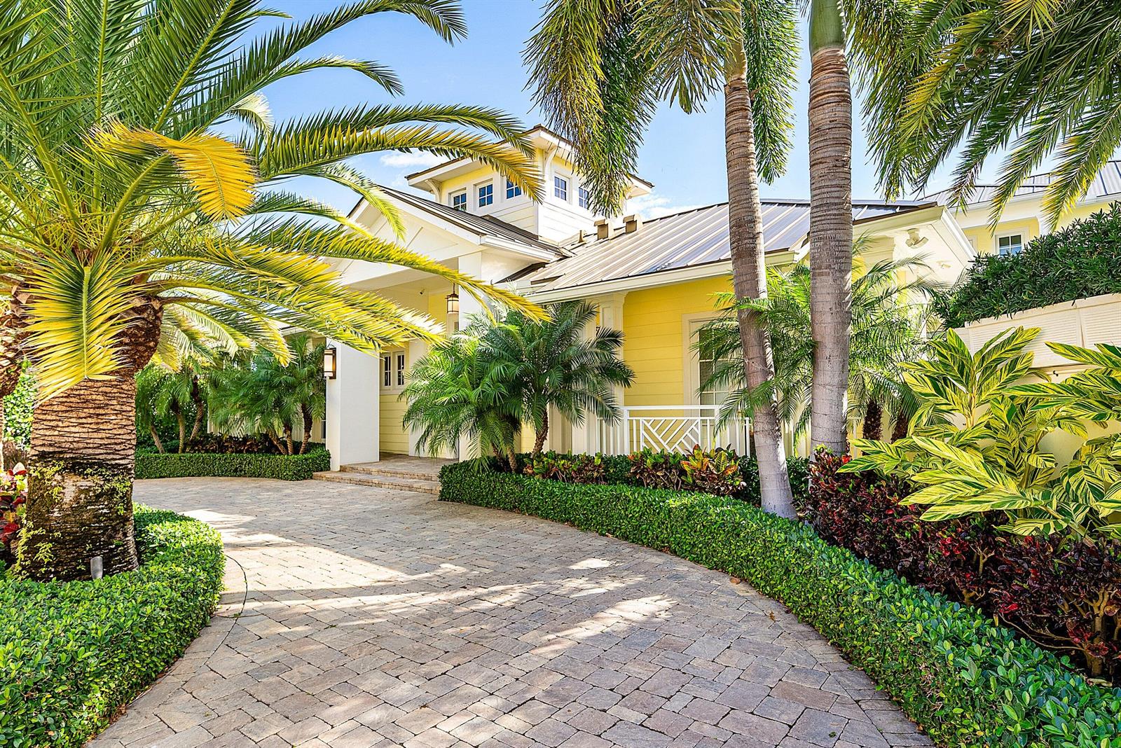 A yellow house with a metal roof and palm trees sits behind a paved driveway — 201 NE 3rd Court, Boca Raton FL 33432, BOCA RATON, FL