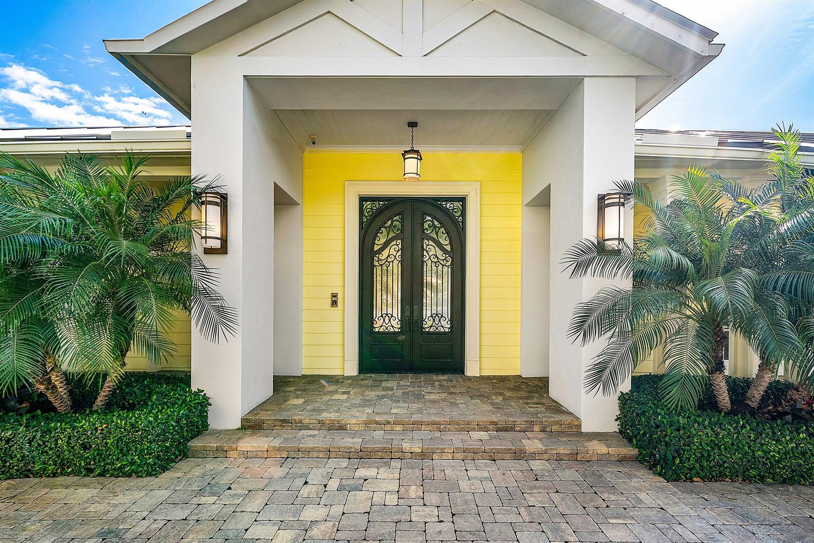 A yellow-walled entryway features a double arched iron door, stone steps, and two palm trees — 201 NE 3rd Court, Boca Raton FL 33432, BOCA RATON, FL